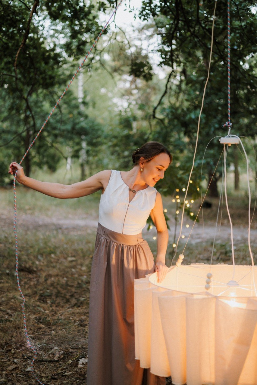 Olga working by hand with fabric for a pleated lamp