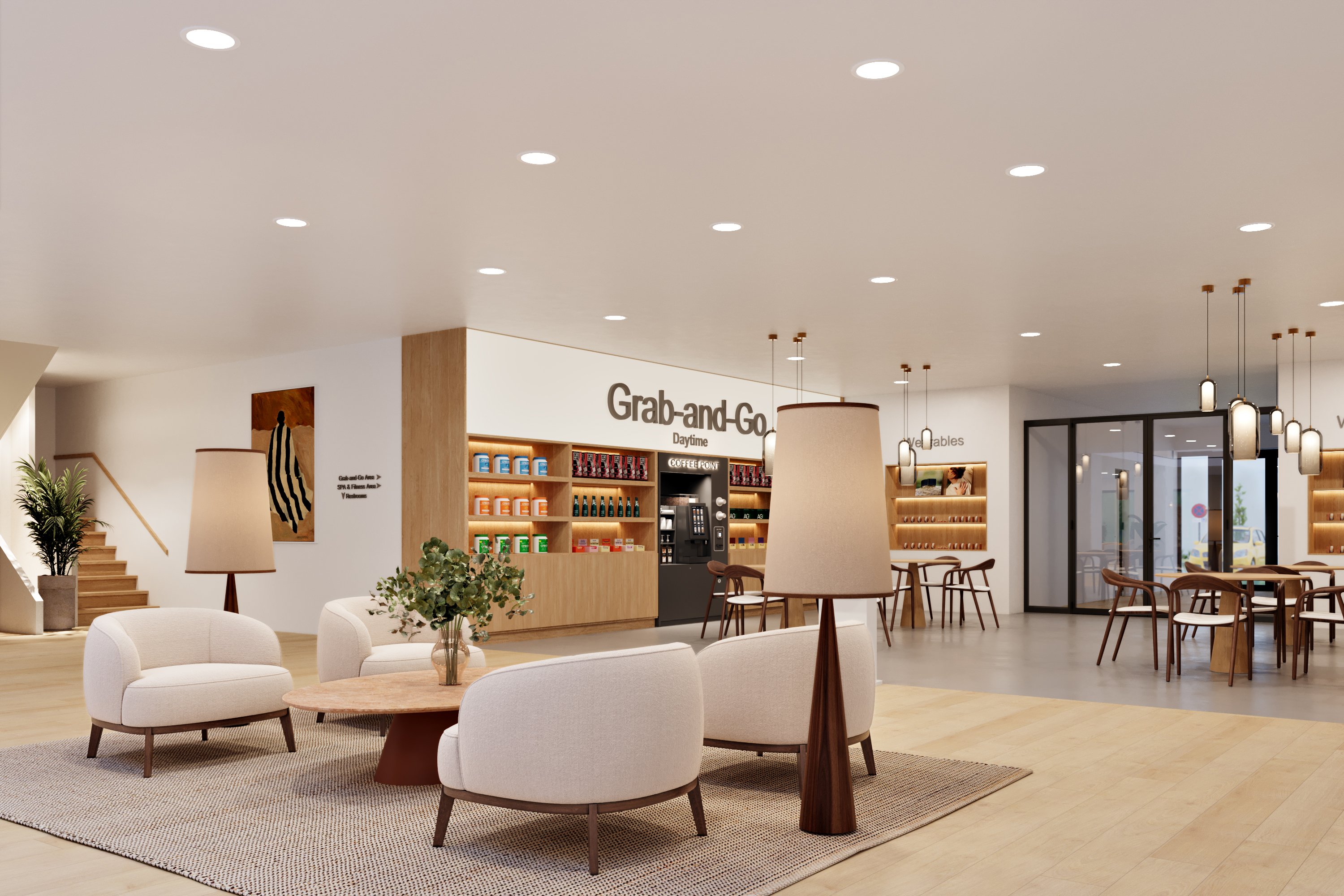 A hotel lounge with soft armchairs, a grab-and-go point and warm pendant lighting